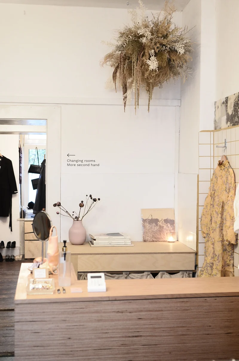 Stylish interior design of contemporary clothes shop or dressmaker studio with wooden counter and dressing room